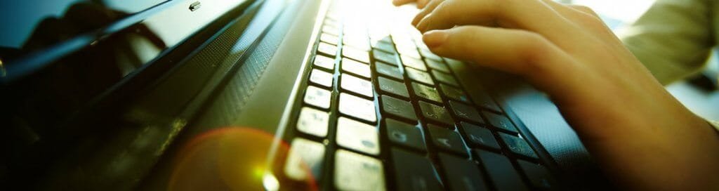 Systeembeheer uitbesteden: handen op het toetsenbord van een laptop