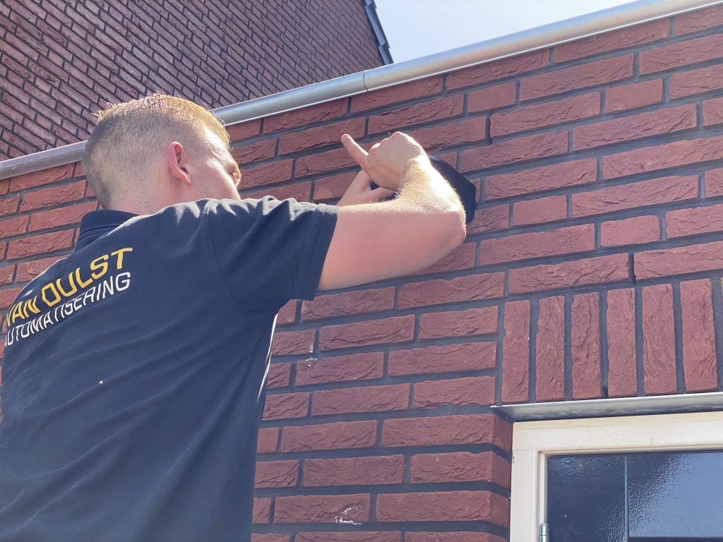 Monteur van Van Dulst aan het werk bij een bakstenen gevel