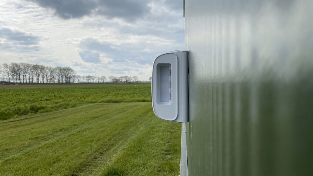Buitenbeveiliging met een witte buitenmelder aan de gevel van een loods